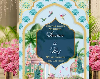 May include: A wedding welcome sign with a blue and gold background featuring peacocks, flowers, and birds. The text reads "Welcome to our Wedding Simran & Raj We are so happy you are here!"