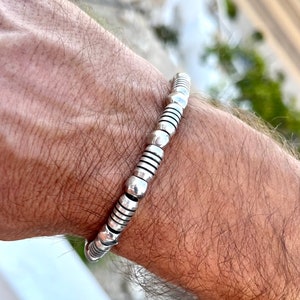 Peut inclure: Un bracelet en argent composé de petites perles rondes, assemblées en boucle continue. Le bracelet a un design simple.