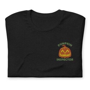 Könnte beinhalten: Schwarzes T-Shirt mit einer grünen und orangefarbenen Kürbisgrafik und dem Text "Pumpkin Inspector".