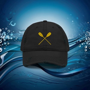 May include: A black distressed baseball cap with a gold embroidered design of two crossed oars.