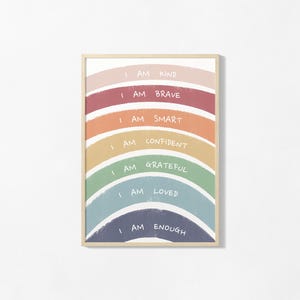 May include: A framed wall art print featuring a rainbow with seven coloured arches in muted tones. Each arch contains white handwritten text: I AM KIND, I AM BRAVE, I AM SMART, I AM CONFIDENT, I AM GRATEFUL, I AM LOVED, and I AM ENOUGH.
