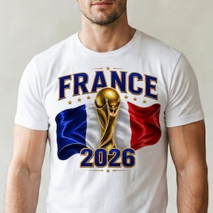 May include: White t-shirt featuring a graphic design with the word "FRANCE" in blue, gold stars, and the French flag. A gold trophy and the number "2026" are also displayed on the shirt.