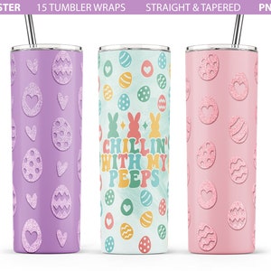 May include: Three stainless steel tumblers with different Easter-themed designs. The first tumbler is purple with a pattern of hearts and eggs. The second tumbler is white with a blue watercolor background and a pattern of eggs, bunnies, and the text "Chillin' with my peeps". The third tumbler is pink with a pattern of hearts and eggs.