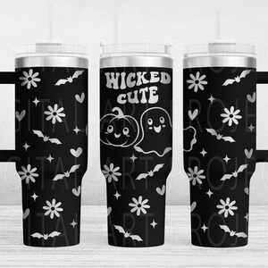 May include: Black tumbler with a handle, featuring a white pattern of flowers, bats, hearts, and stars. The center of the tumbler has the words "WICKED CUTE" with a pumpkin and ghost illustration.
