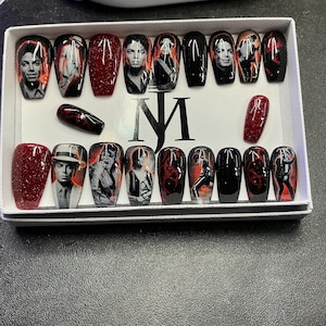 May include: A set of twenty-four press-on nails in a white box featuring the letters MJ. The nails are decorated with black and red glitter, and various black and white photographic portraits and silhouettes of Michael Jackson in different poses.