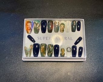 May include: A set of 14 blue and white press-on nails with images of characters from the TV show "Supernatural". The nails are arranged in a white box with the word "Supernatural" printed on the front.