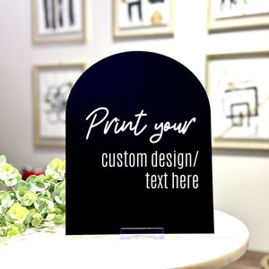 May include: Black arched sign with a white stand. The sign says "Print your custom design/ text here".