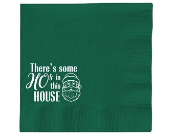 May include: Green paper napkin with a white design that says "There's some HO HO in this HOUSE" with a Santa Claus illustration.