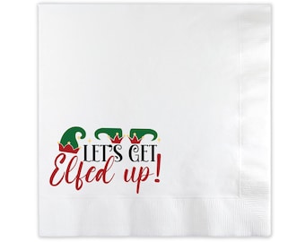 May include: White paper napkins with a festive Christmas design. The napkins feature three green elf hats with red trim and gold stars. The text "Let's Get Elfed Up!" is printed in red and black.