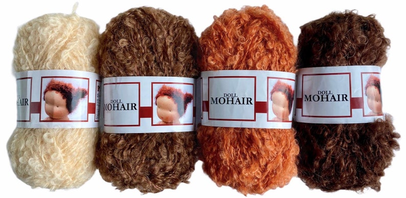 May include: Four skeins of doll mohair yarn in varying shades of brown, orange, and cream. Each skein is wrapped with a label featuring a doll's face and the text "DOLL MOHAIR". The yarn has a curly, textured appearance.