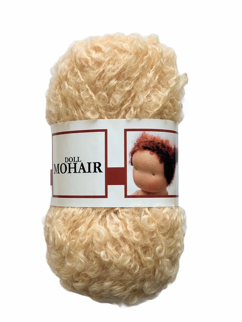 May include: A ball of light beige doll mohair yarn. The yarn is tightly curled and has a soft, fluffy texture. A label wrapped around the yarn reads "DOLL MOHAIR" and features an image of a doll's face.