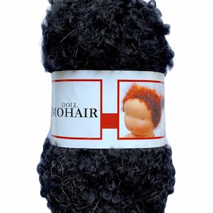 May include: A dark gray ball of doll mohair yarn. The yarn is tightly curled and wrapped with a label that reads "DOLL MOHAIR" and features an image of a doll with red hair. The background is white.