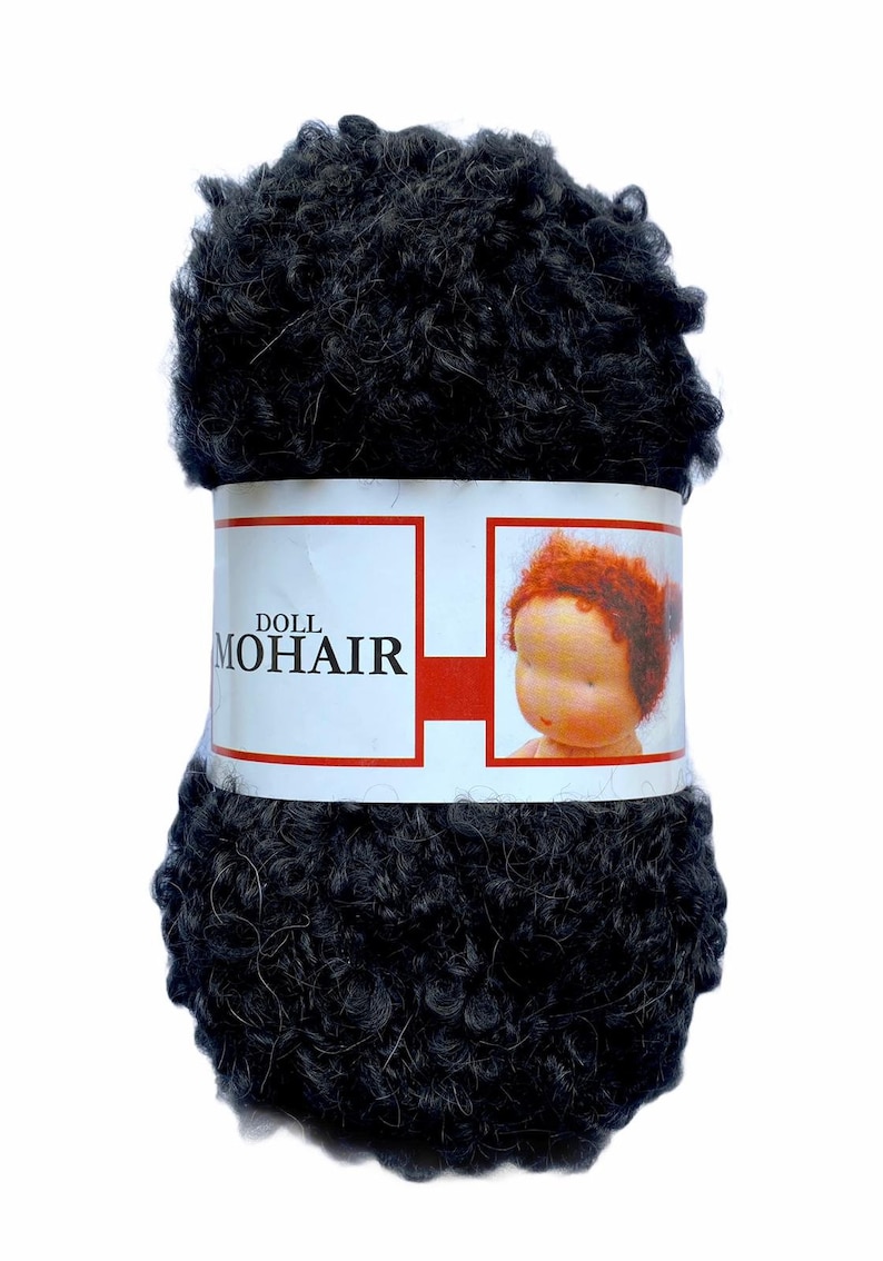 May include: A dark gray ball of doll mohair yarn. The yarn is tightly curled and wrapped with a label that reads "DOLL MOHAIR" and features an image of a doll with red hair. The background is white.