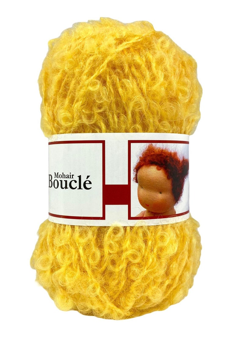 May include: A skein of bright yellow Mohair Boucl&eacute; yarn. The yarn is tightly wound and has a curly, textured appearance. The label features the text "Mohair Boucl&eacute;" and an illustration of a doll.
