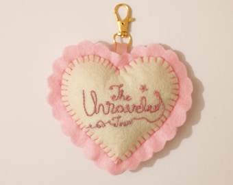 Charm para bolso personalizado de fieltro de felpa con corazón bordado a mano y doble cara de la gira The Unraveled Tour.