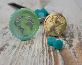 May include: Two wax seals with a world map design. One seal is green with silver accents, and the other is gold. There are also several teal wax seals scattered around.