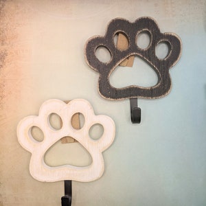 May include: Two wooden paw print hooks, one white and one black, with metal hooks.