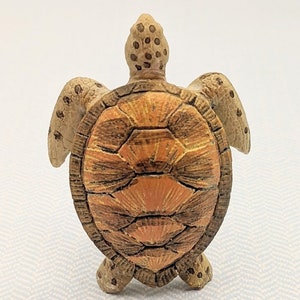 May include: A small, brown and orange ceramic turtle figurine with a detailed shell pattern.