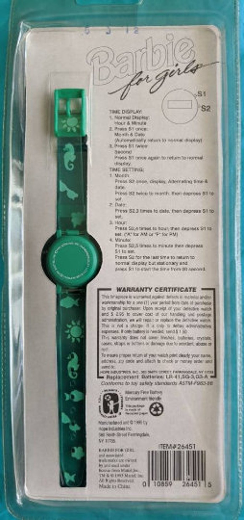 Peut inclure: Une montre Barbie pour filles, de couleur verte et blanche, avec un affichage num&eacute;rique. La montre pr&eacute;sente divers motifs sur le th&egrave;me de la mer, notamment un soleil, un hippocampe et des poissons. La montre est emball&eacute;e dans un bo&icirc;tier en plastique transparent avec un fond blanc et un certificat de garantie.