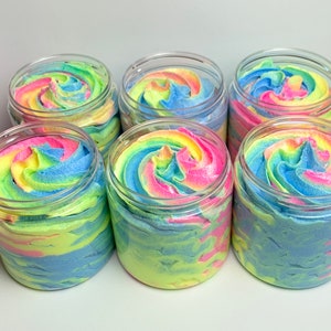 May include: Six clear jars filled with colorful whipped soap. The soap is swirled with shades of pink, blue, green, and yellow.