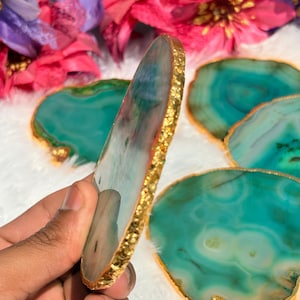May include: Set of four green agate coasters with gold foil trim. The coasters are round and have a natural, organic shape.