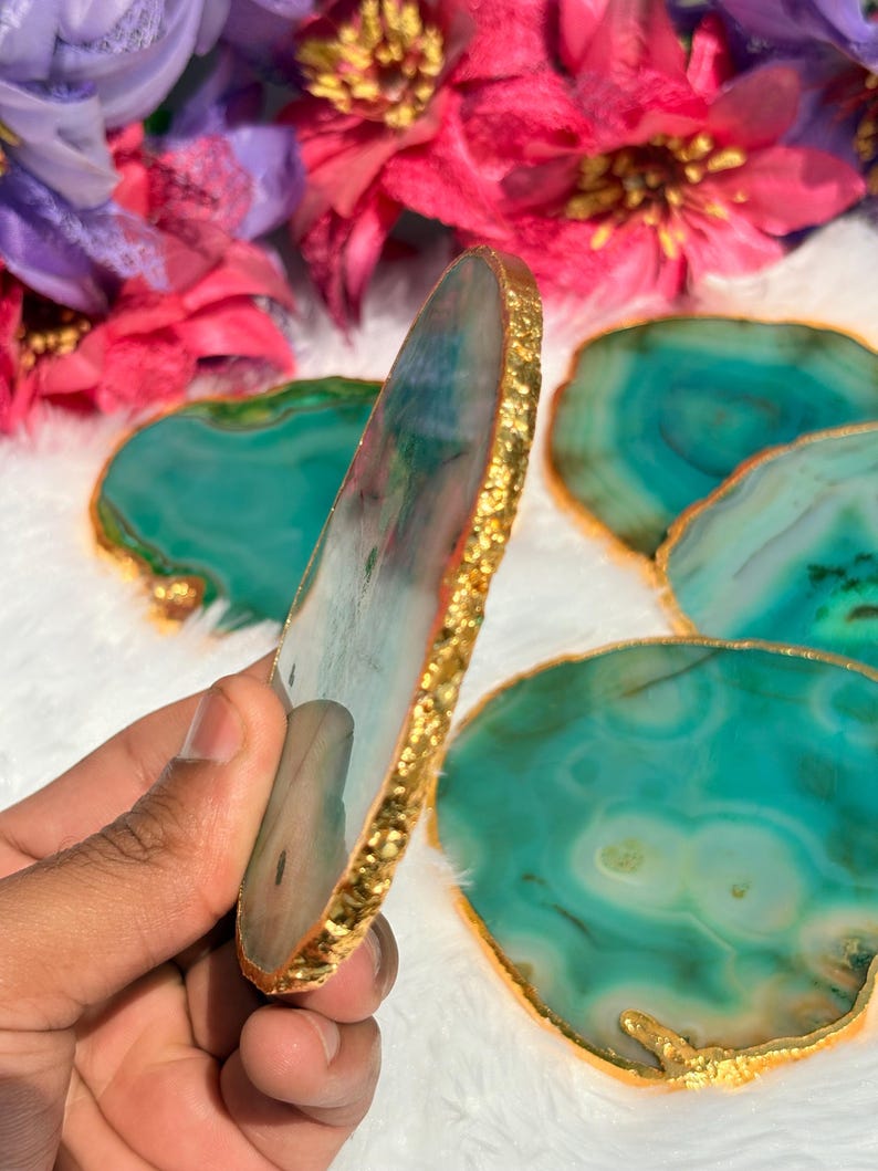 May include: Set of four green agate coasters with gold foil trim. The coasters are round and have a natural, organic shape.