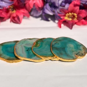 May include: Four green agate coasters with gold trim. The coasters are stacked on top of each other.