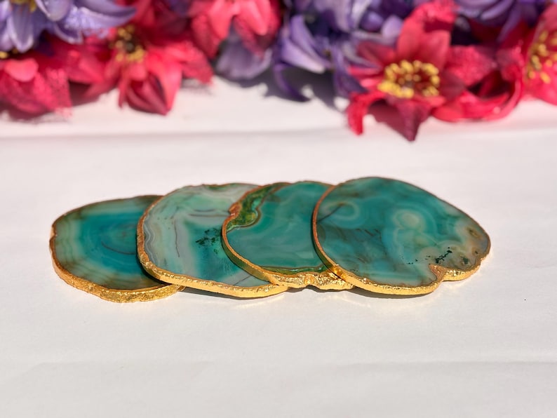 May include: Four green agate coasters with gold trim. The coasters are stacked on top of each other.