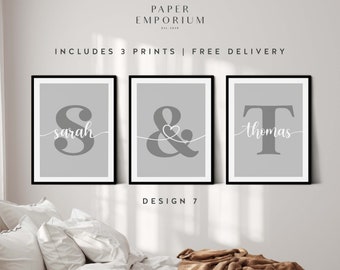May include: Three gray framed prints with white lettering. The first print features the letter "S" with the name "sarah" written underneath. The second print features an ampersand with a small heart in the center. The third print features the letter "T" with the name "thomas" written underneath. The prints are titled "Design 7" and are described as "The perfect gift for your loved ones".