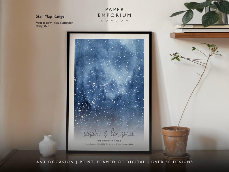 May include: Framed star map print with a watercolor-style night sky in shades of blue and white. The print includes the names "sarah & lanrence" and the text "THE NIGHT WE MET" with a date and location. The print is displayed on a wall.