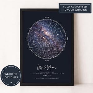 May include: A framed star map print in navy blue, with a detailed depiction of the night sky. The print includes the names "Lily & Marcus", date, and location. The top of the frame reads "FULLY CUSTOMISED TO YOUR WORDING". A circular sticker says "WEDDING DAY GIFTS".