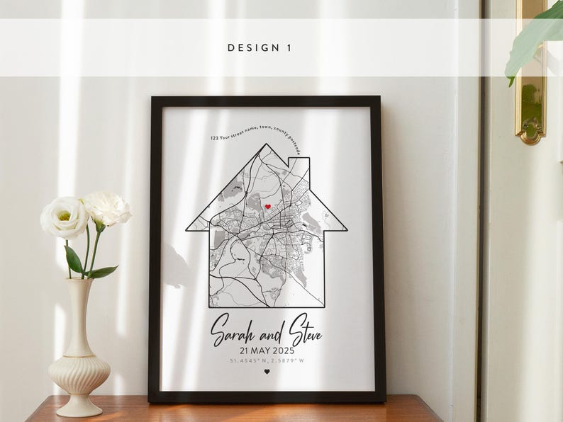 May include: A black framed print with a white background featuring a map of a city with a red heart marking a location. The text "Sarah and Steve 21 MAY 2025" is below the map.