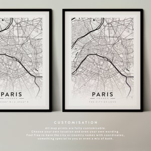 May include: Two black framed prints of a map of Paris, France. The top print has the text "Paris, France" and coordinates. The bottom print has the text "Paris, France - The City of Love".