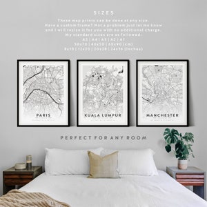 May include: Three black framed prints of city maps, with the city names "Paris", "Kuala Lumpur", and "Manchester" printed below each map. The text "SIZES" is at the top of the image, followed by information about the available sizes of the prints in both centimeters and inches. The text "PERFECT FOR ANY ROOM" is at the bottom of the image.