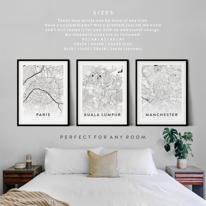 May include: Three black framed prints of city maps, with the city names "Paris", "Kuala Lumpur", and "Manchester" printed below each map. The text "SIZES" is at the top of the image, followed by information about the available sizes of the prints in both centimeters and inches. The text "PERFECT FOR ANY ROOM" is at the bottom of the image.