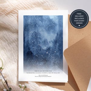 以下が含まれることがあります： 青と白の星空のデザインが施された白いカード。上部に「THE START OF FOREVER」の文字があり、詳細が下に記載されています。茶色の封筒が一部見えています。