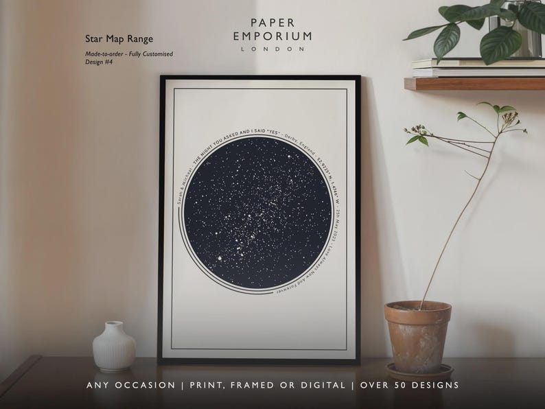 May include: A framed star map print with a black frame. The print features a dark blue circle filled with white stars, with text around the circle. The text reads "Sarah & Michael: THE NIGHT YOU ASKED AND I SAID 'YES'" and other details. The print is displayed on a wall.