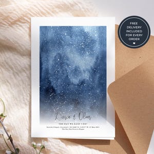May include: A wedding invitation featuring a blue and white watercolour design. The text reads "Darcie & Oliver" and "The Day We Said 'I Do'". Includes the wedding location and date. A round sticker states "Free Delivery Included For Every Order".