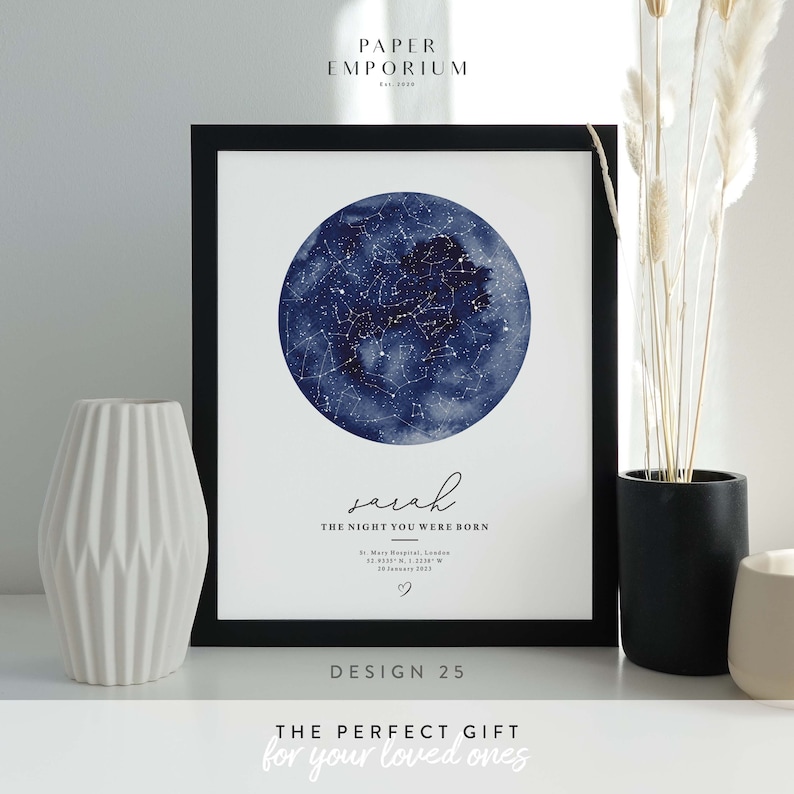 May include: A navy blue watercolor star map print with a white border and a black frame. The print features a circle of stars with a white heart in the center. The text "sarah THE NIGHT YOU WERE BORN" is printed below the star map. The text "St. Mary Hospital, London 12.413311138 W 20 January 2023" is printed below the name. The text "DESIGN 25" is printed below the image. The text "THE PERFECT GIFT for your loved ones" is printed below the design number.