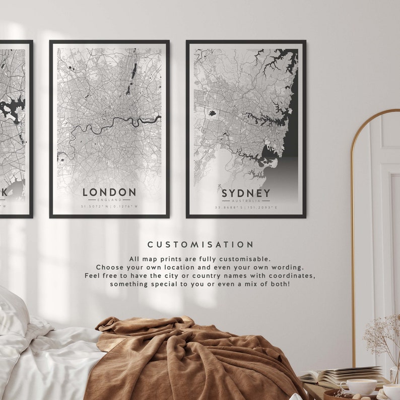 May include: Three black framed prints of city maps with the city names and coordinates printed below each map. The maps are in black and white and show the street layout of the cities. The text below the maps reads "CUSTOMISATION" and "All map prints are fully customisable. Choose your own location and even your own wording. Feel free to have the city or country names with coordinates, something special to you or even a mix of both!"