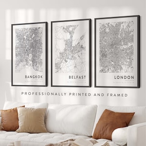 May include: Three black framed prints of city maps with the city names and coordinates printed below each map. The maps are of Bangkok, Thailand; Belfast, Ireland; and London, England. The text "Professionally Printed and Framed" is printed below the maps.