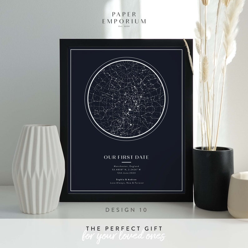 May include: A black framed print with a dark blue background featuring a white star constellation map. The text "OUR FIRST DATE" is below the map with the location "Manchester, England" and date "12th June 2023". The text "Sophie & Andrew" is below the date. The text "Love Always, Now & Forever" is below the names. The text "DESIGN 10" is below the print. The text "THE PERFECT GIFT for your loved ones" is below the design number.