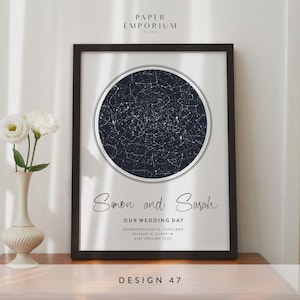 May include: Framed print featuring a dark blue celestial map within a white circle, with the names "Simon and Sarah" and wedding details below. The print is in a black frame, with the text "DESIGN 47" at the bottom.