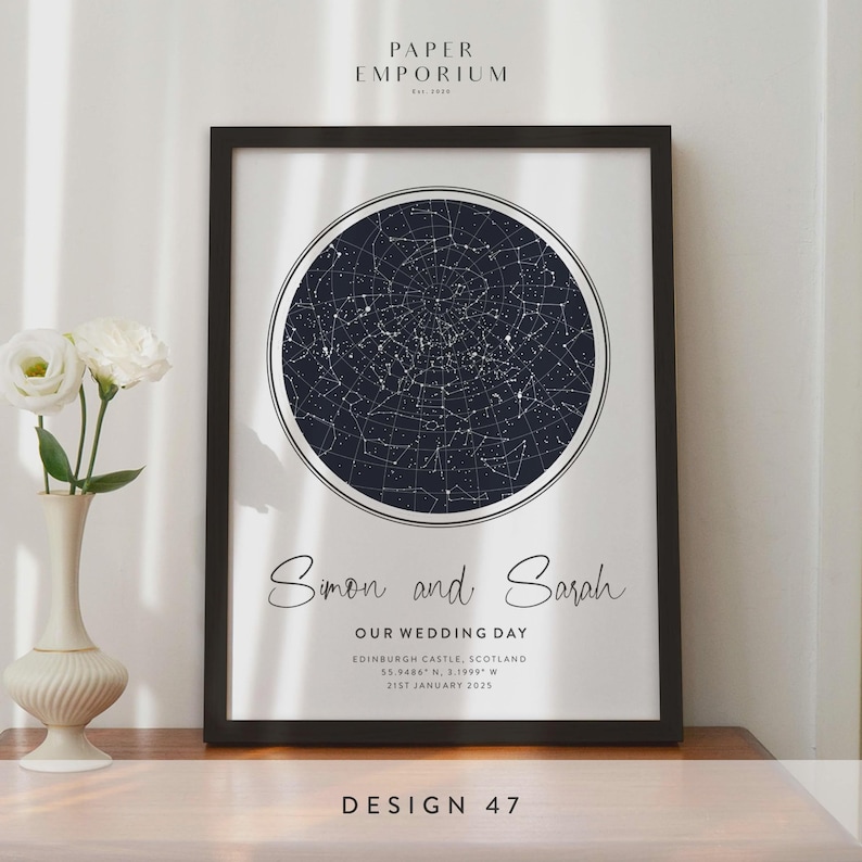 May include: Framed print featuring a dark blue celestial map within a white circle, with the names "Simon and Sarah" and wedding details below. The print is in a black frame, with the text "DESIGN 47" at the bottom.