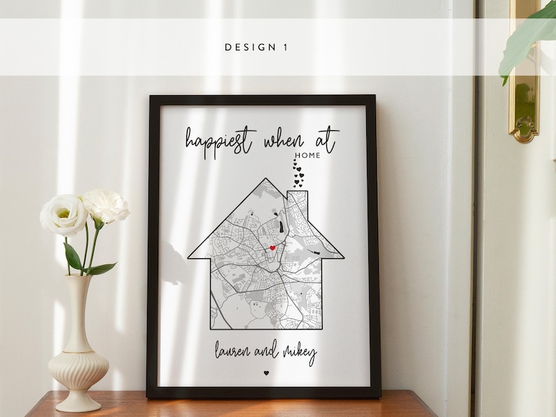May include: A black framed print with the text "Happiest when at home" and a map of a city with a red heart in the center. The text "Lauren and Mikey" is below the map.