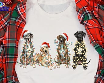 May include: White t-shirt with a festive design of four Great Dane dogs, each wearing a Santa hat and adorned with Christmas lights. The dogs are in different poses. The background is a red and green plaid pattern.