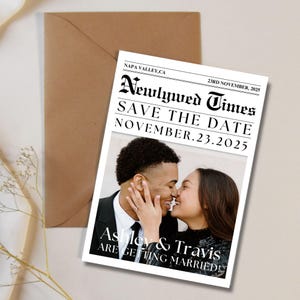 May include: A save the date announcement for a wedding. The announcement is styled like a newspaper with the headline "Newlywed Times". The announcement features a photo of a couple kissing and the text "Save the Date November 23, 2025 Ashley & Travis Are Getting Married!"