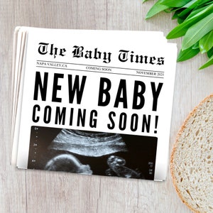 May include: A newspaper announcement with the headline "The Baby Times" and the text "New Baby Coming Soon!"  The announcement includes a black and white ultrasound image.