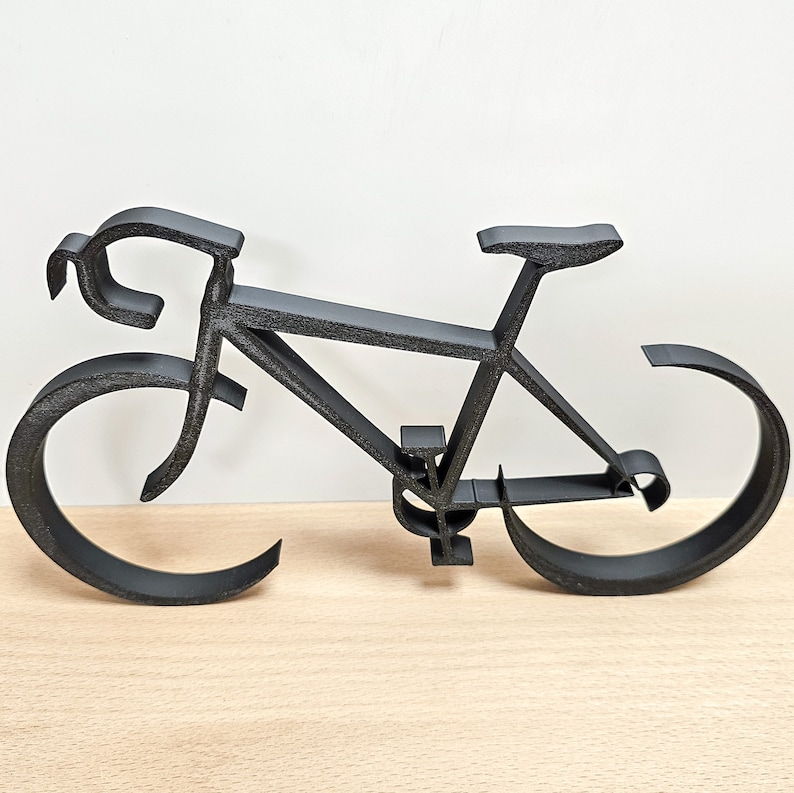 Puede incluir: Una escultura de bicicleta de metal negro. La escultura est&aacute; hecha de metal delgado y tiene un dise&ntilde;o simple y minimalista.