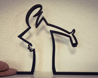 May include: Black metal silhouette of a person with arms outstretched, standing on a black base. The silhouette is a stylized representation of a person.